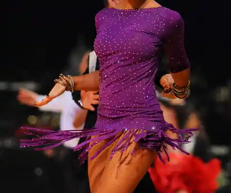 Latin dancer in sparkling purple costume at a Candela Fridays salsa social in New York