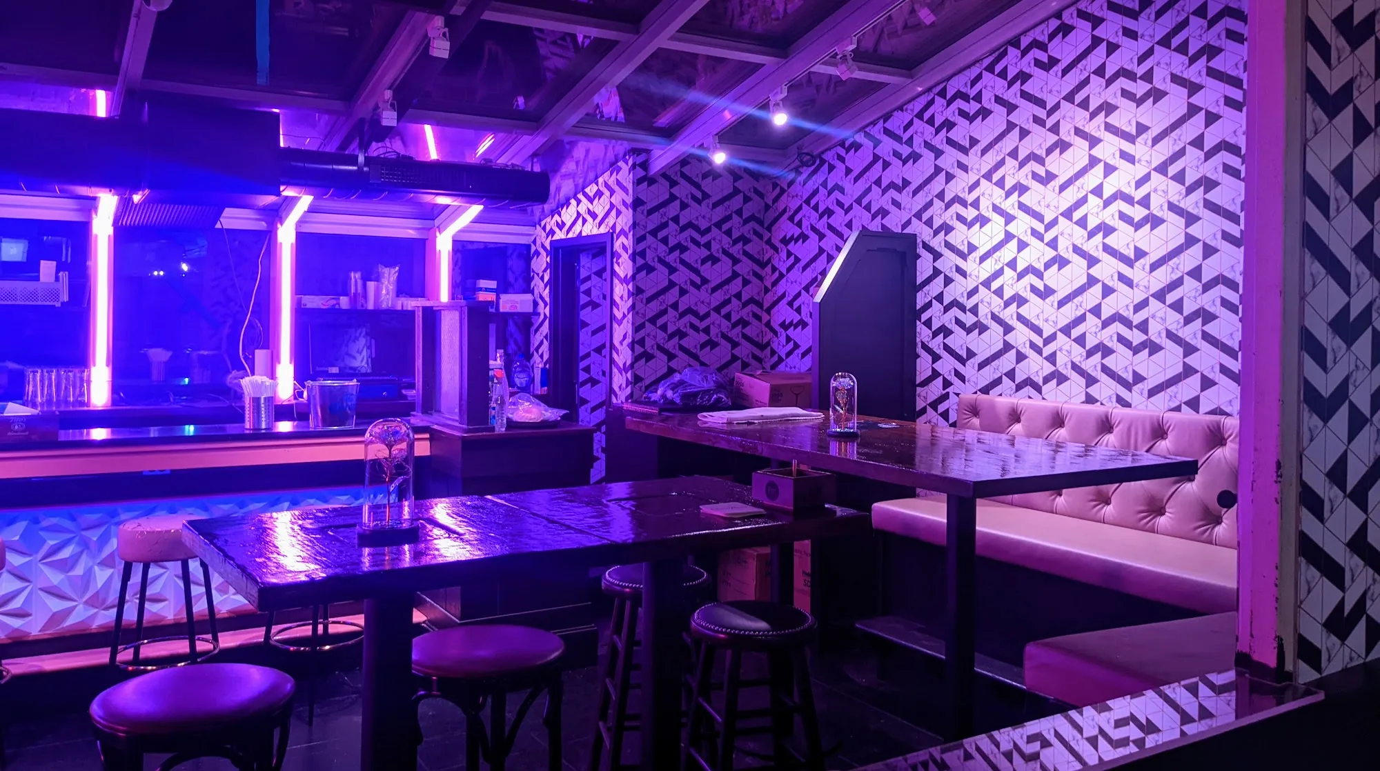 Interior lounge with purple club lighting and banquette seating at The Rose NYC