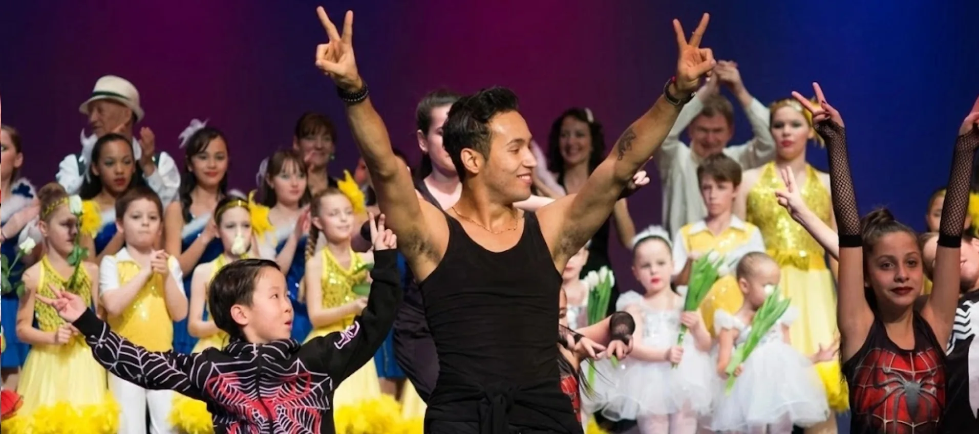Recital finale with an instructor and costumed young dancers celebrating on stage at LaVida Dance Studio, Seattle.