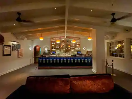 Empty bar interior with blue-tiled counter and globe pendants at The Bungalow in Long Beach — salsa, bachata venue in Long Beach