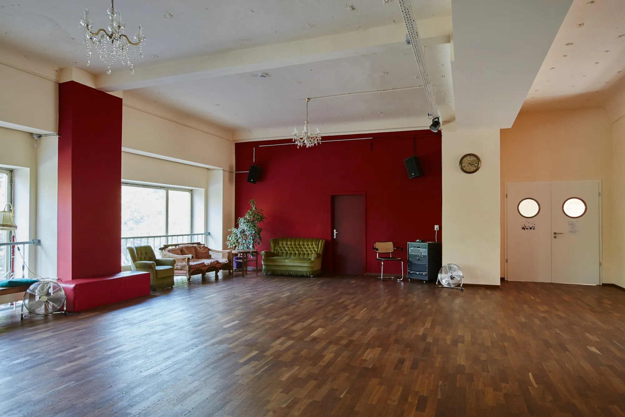 Grand dance hall with red décor and chandelier at Baileo Tanzstudio, Leipzig