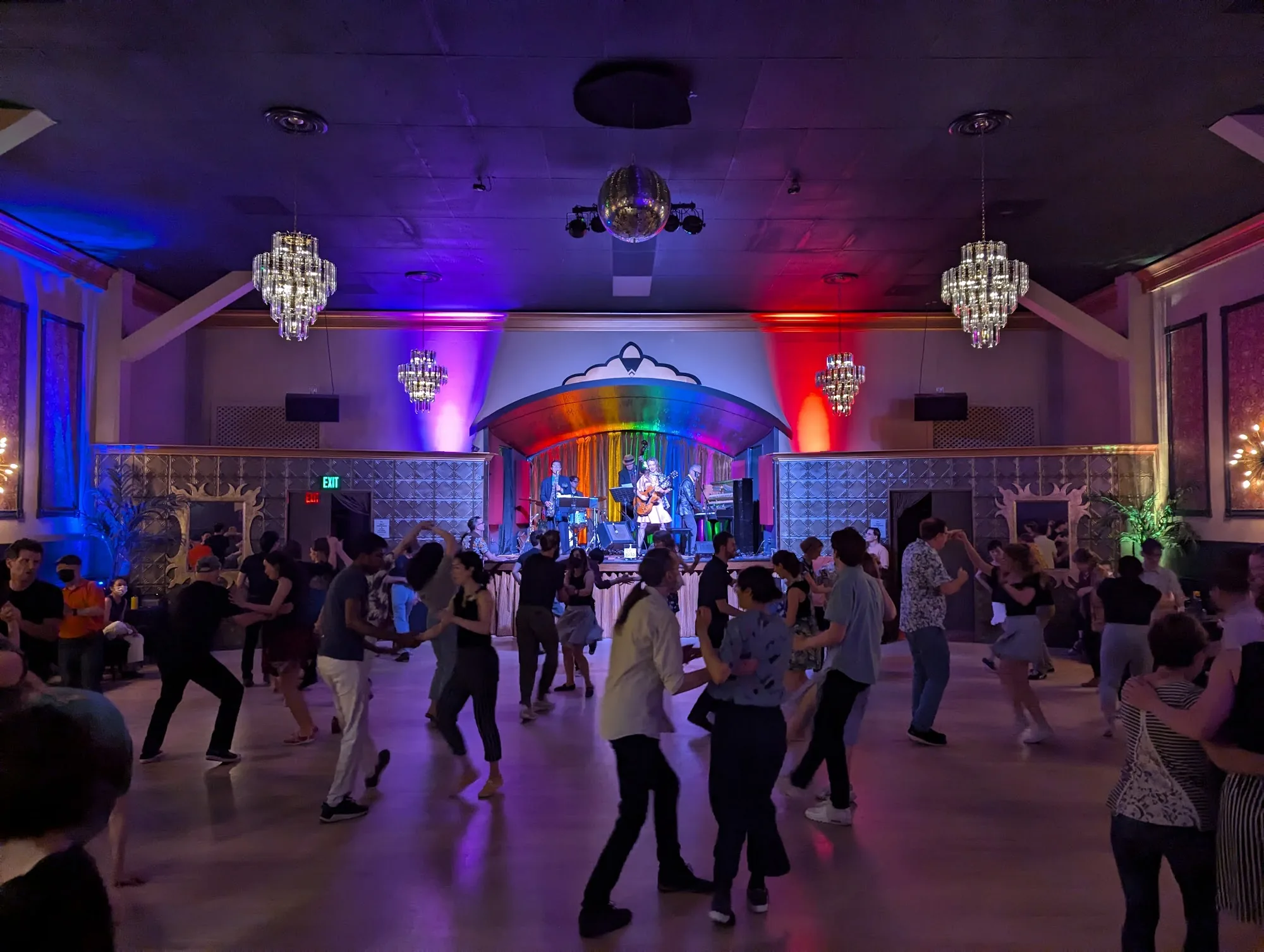 Packed social dance floor with live band and disco ball at Verdi Club San Francisco