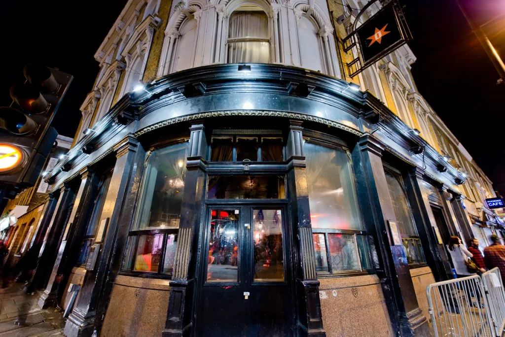 Dogstar Brixton Victorian corner building exterior at night with star sign and illuminated windows
