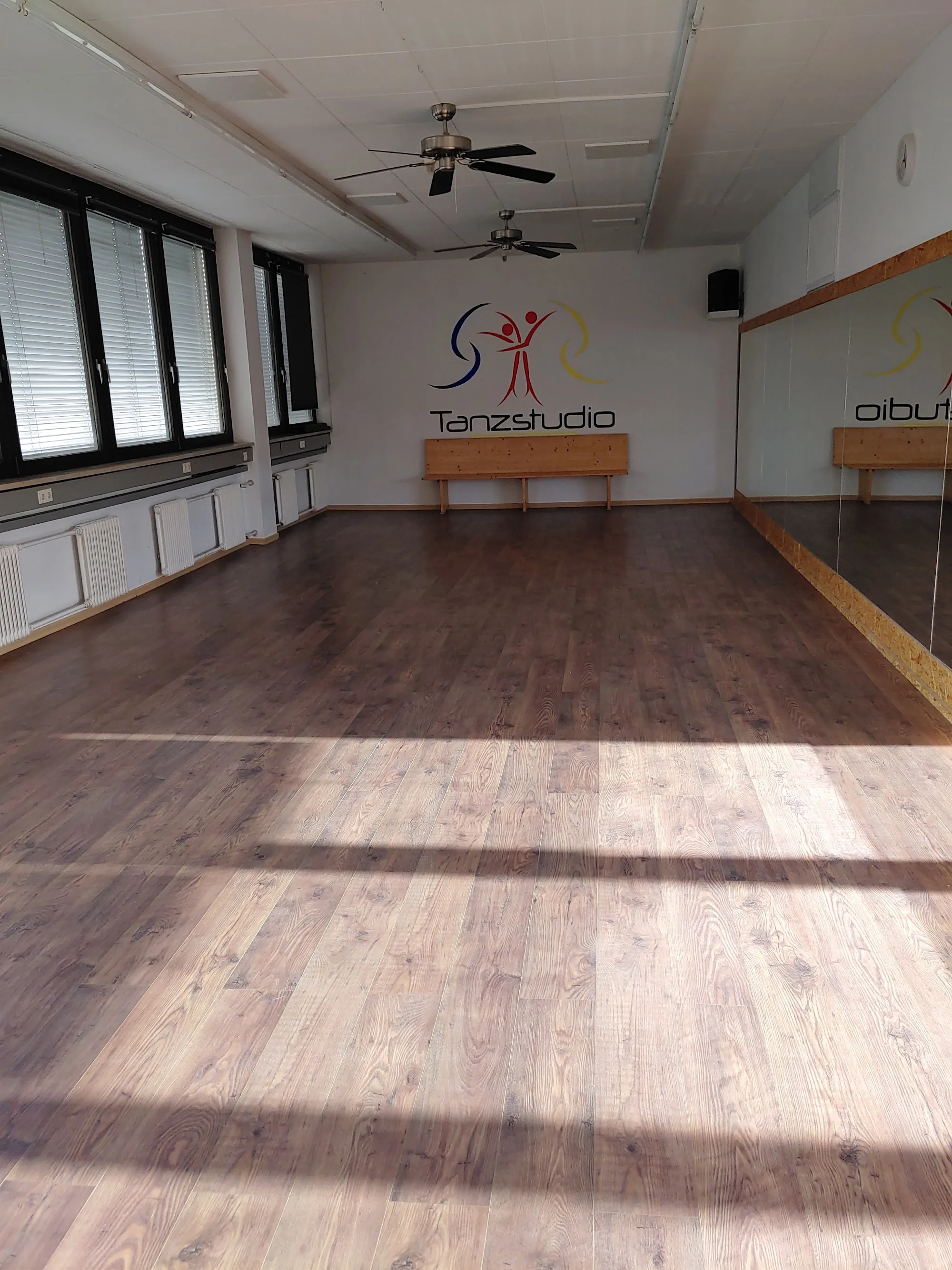 Wooden dance floor with Tanzstudio Rebecca branding and mirror wall at the White Studio in Munich