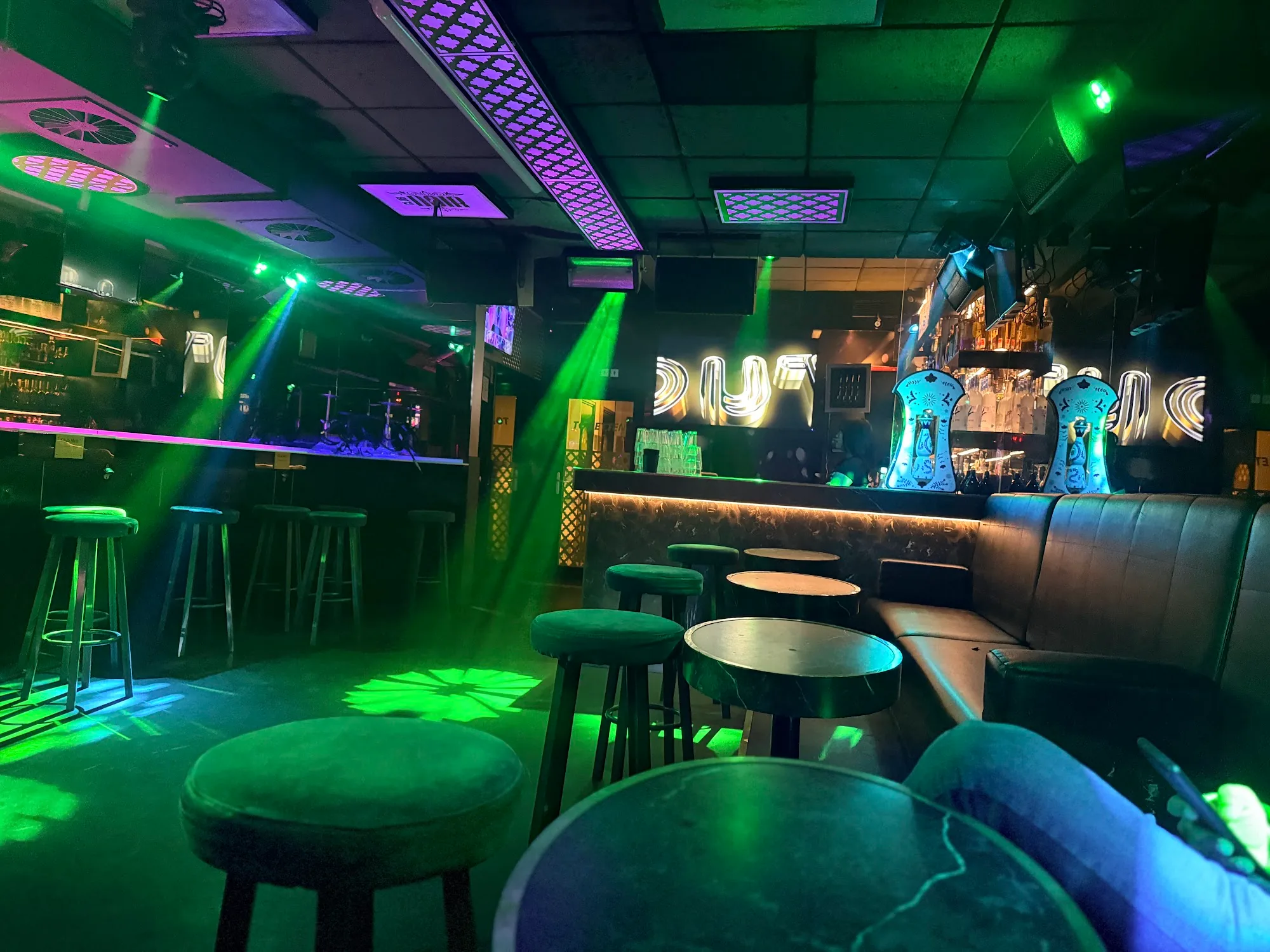 OUT Latin Club Amsterdam — club interior with green laser lighting, DJ booth and bar at back