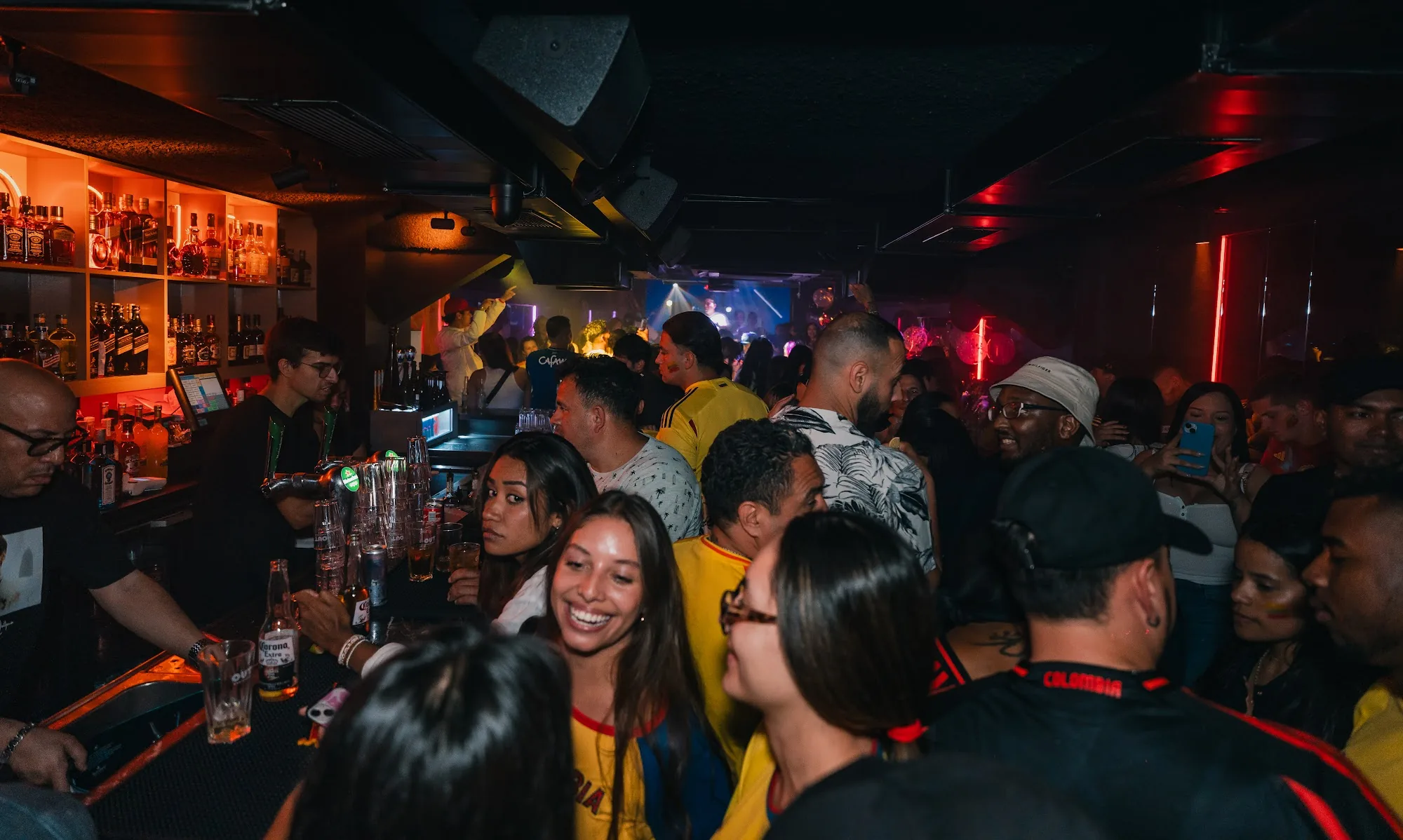 OUT Latin Club Amsterdam — busy event night with crowd at the bar and DJ visible in the background