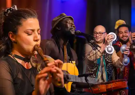 Live Latin band performing with flute, guitar and percussion on stage at Cafe Sor, salsa, bachata venue in Oslo