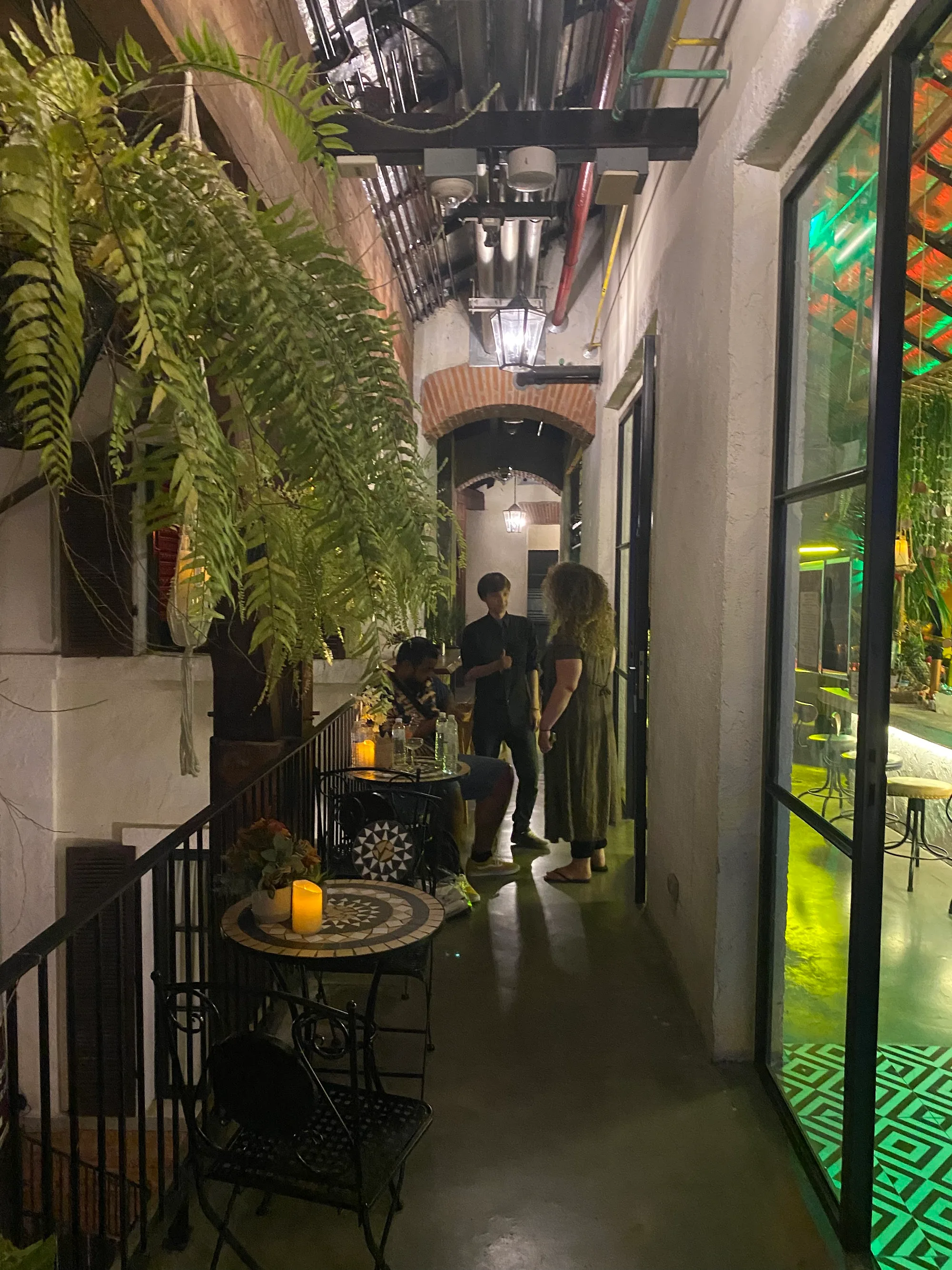 PuraVida Entertainment Chiang Mai — outdoor corridor with tropical plants and view into bar