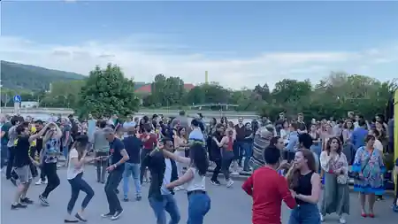 Outdoor salsa social with crowd dancing by the river in Heidelberg, hosted by El Templo