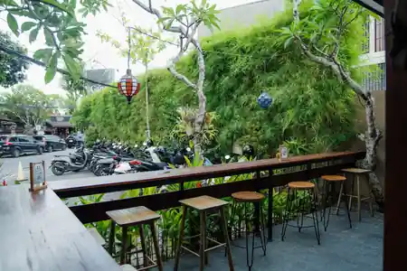 Outdoor bar counter and seating at Pilleyar Bar & Kitchen Bali with lush greenery and lanterns — salsa, bachata, kizomba venue in Bali