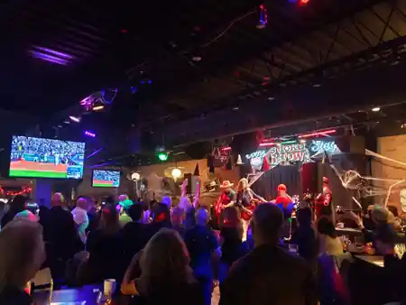 Live band performing on the Coors Smoke Show stage at Smokeshow BBQ and Brew Toronto with a packed crowd under colorful lights, bachata venue in Toronto