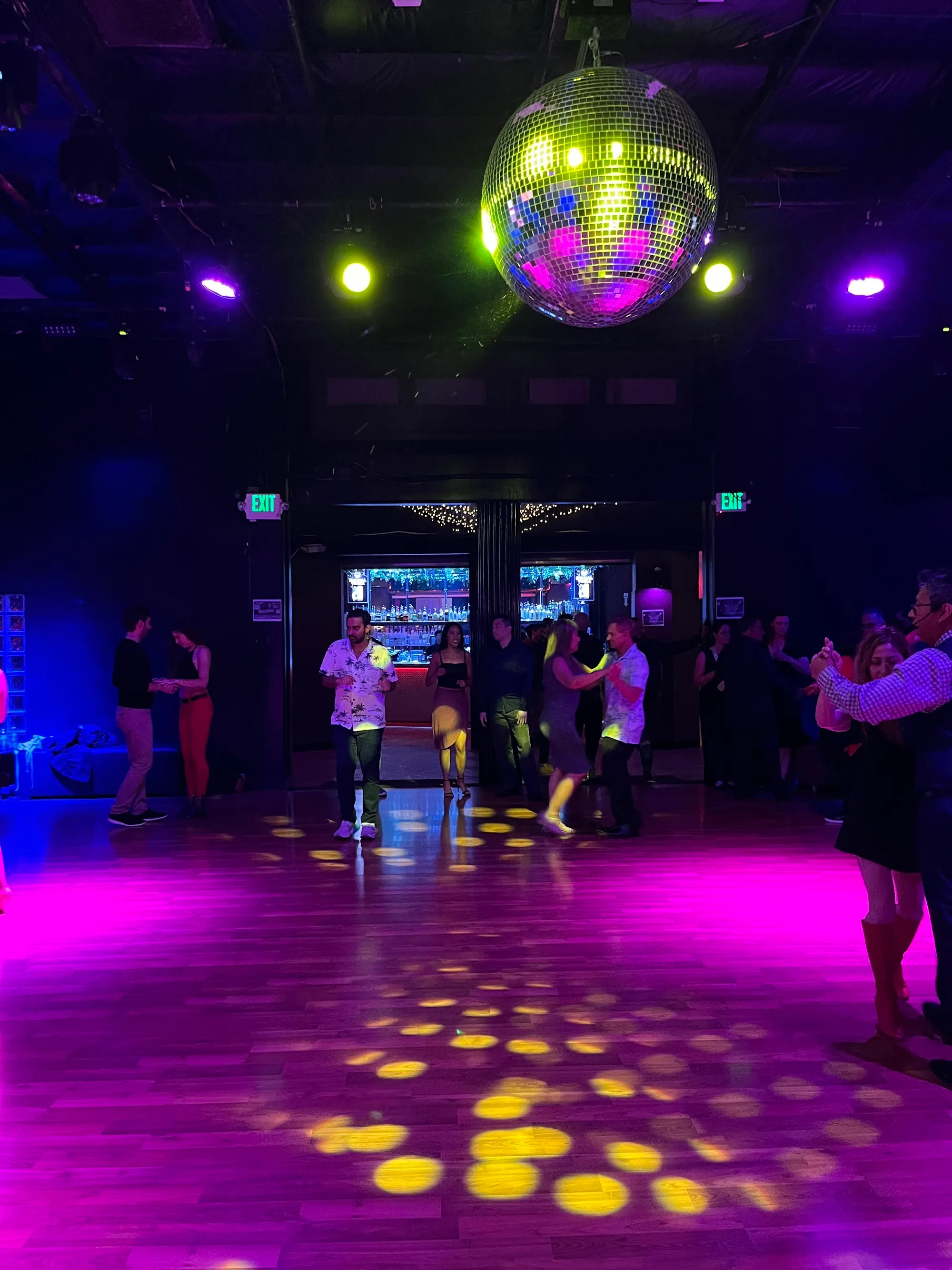Wooden dance floor with mirror ball and salsa dancers at Space 550 in San Francisco
