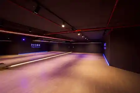 Empty wooden dance floor with mirrored wall and club lighting at Mice Dance School Munich, salsa, kizomba venue in Munich