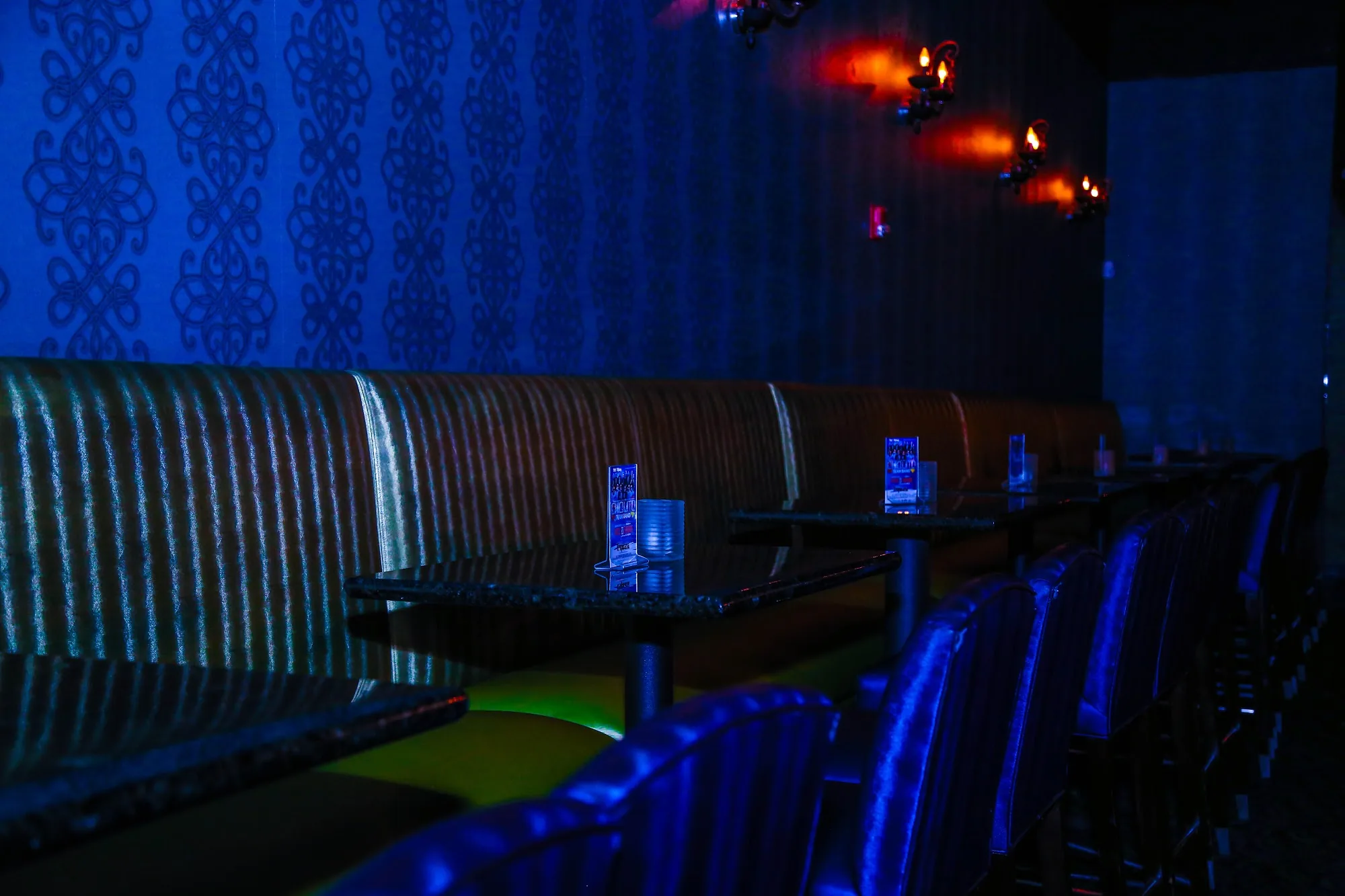 Blue-lit booth lounge seating inside Club Tropicana Latin nightclub, Houston