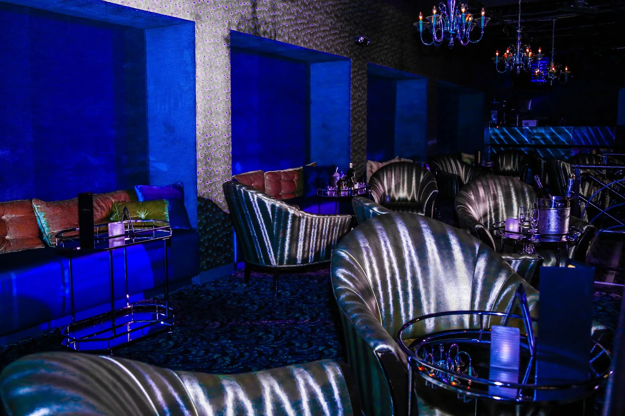 Metallic lounge chairs and chandeliers in the club lounge at Club Tropicana, Houston