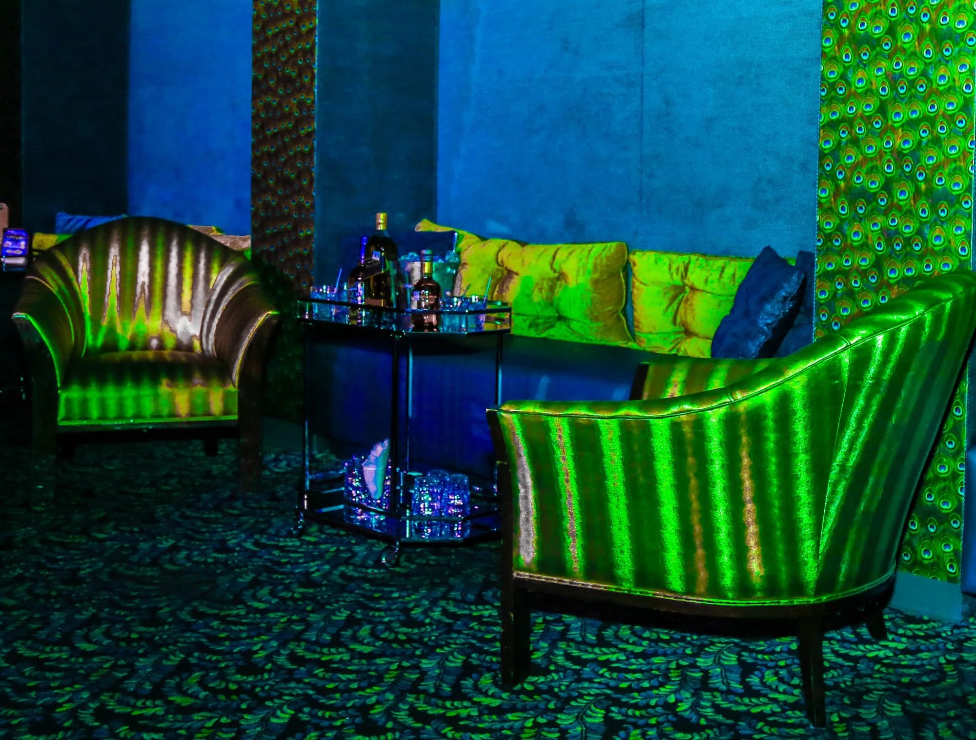 Green and blue lit lounge seating area at Club Tropicana nightclub, Houston
