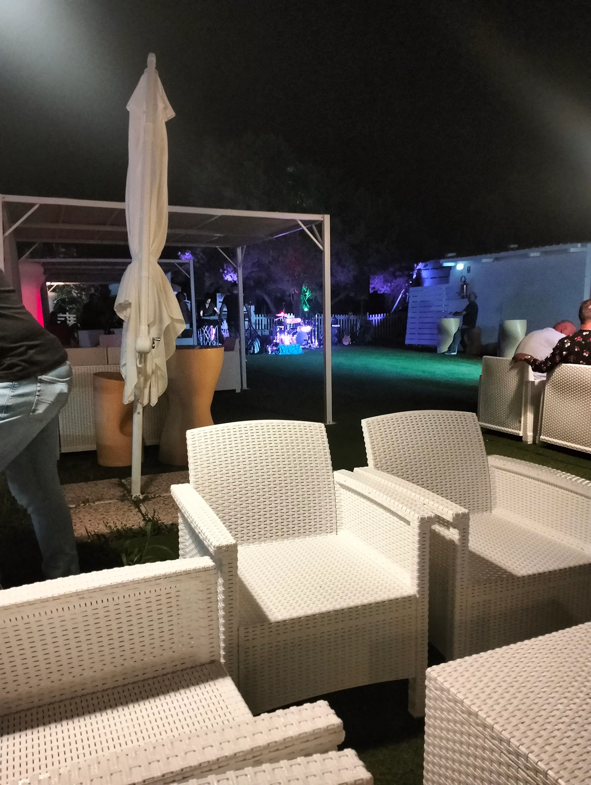 Night party atmosphere with crowd and stage lights at Sea Public, Aspra