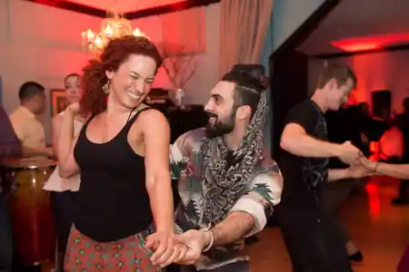 Couple dancing salsa with smiles at The Mambo Outlet social night in Los Angeles