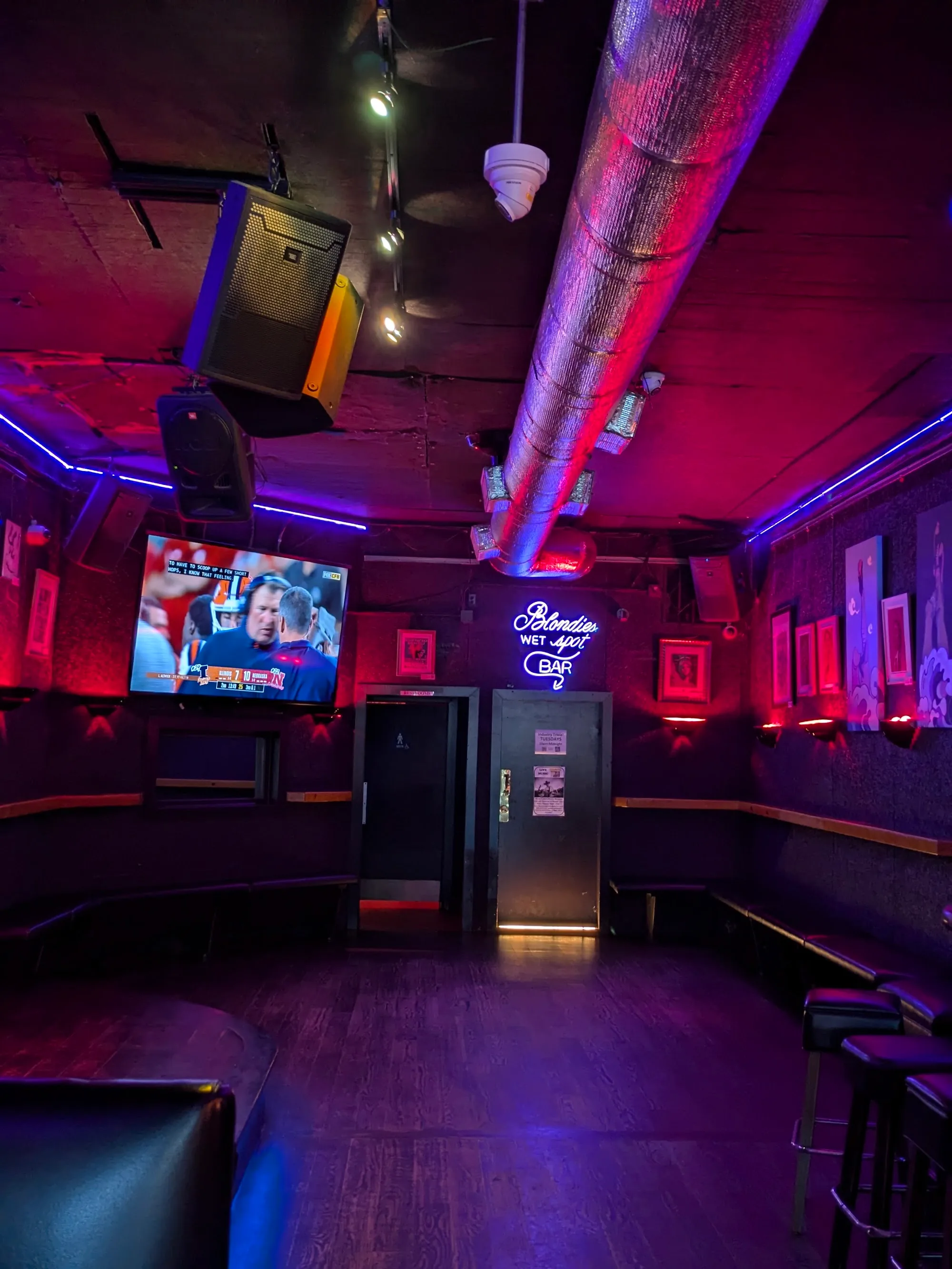Interior of Blondie's Bar San Francisco with neon Wet Spot Bar sign red and blue club lighting and lounge seating