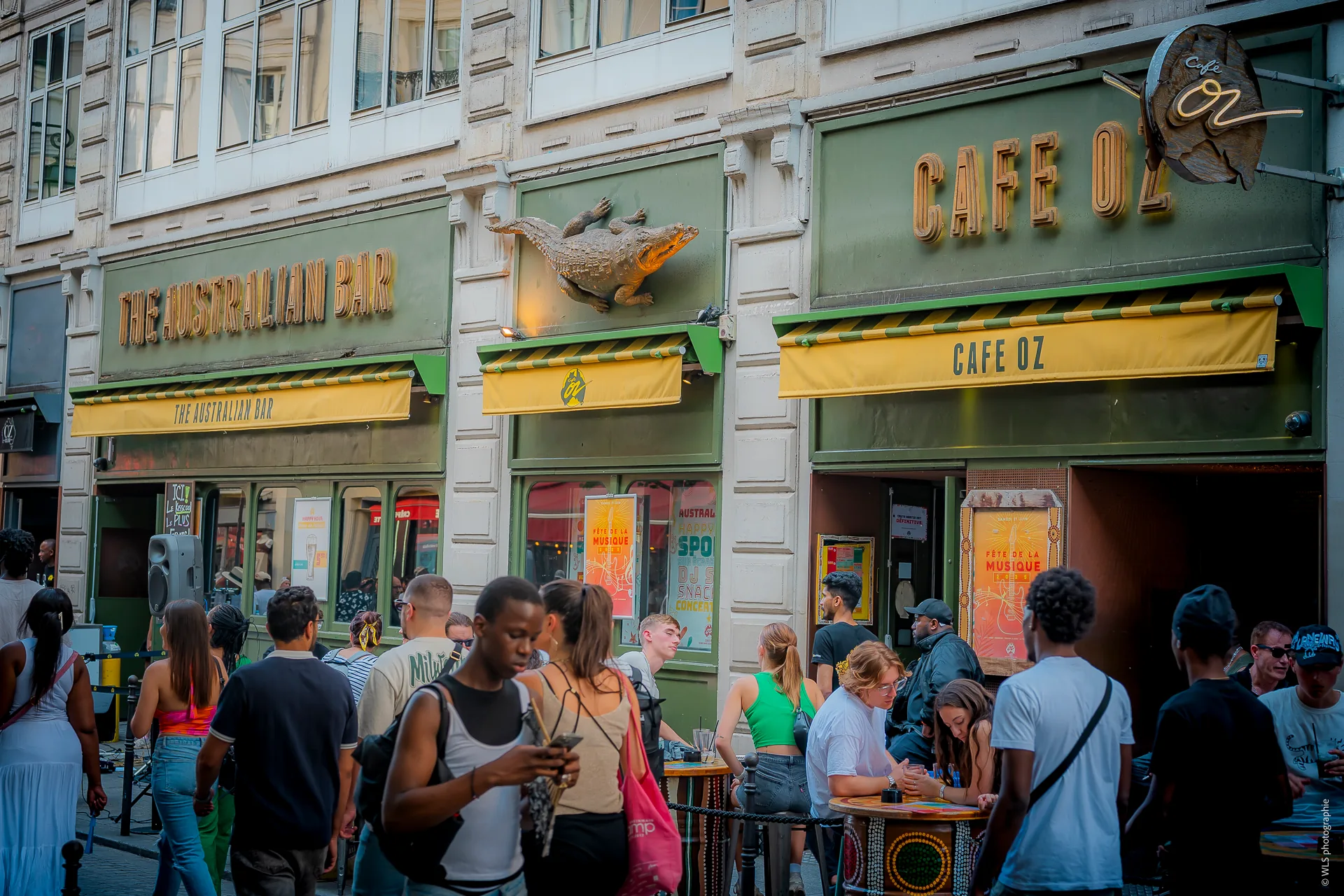 Café Oz branded exterior with crowd gathered on Paris street