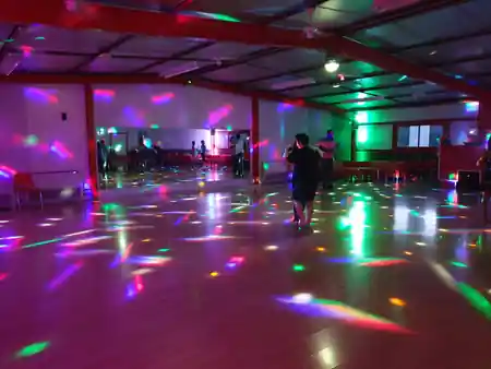Couples dancing on the lit floor at Salle Le Temple Pessac with colourful lights — salsa, bachata, kizomba, zouk venue in Pessac