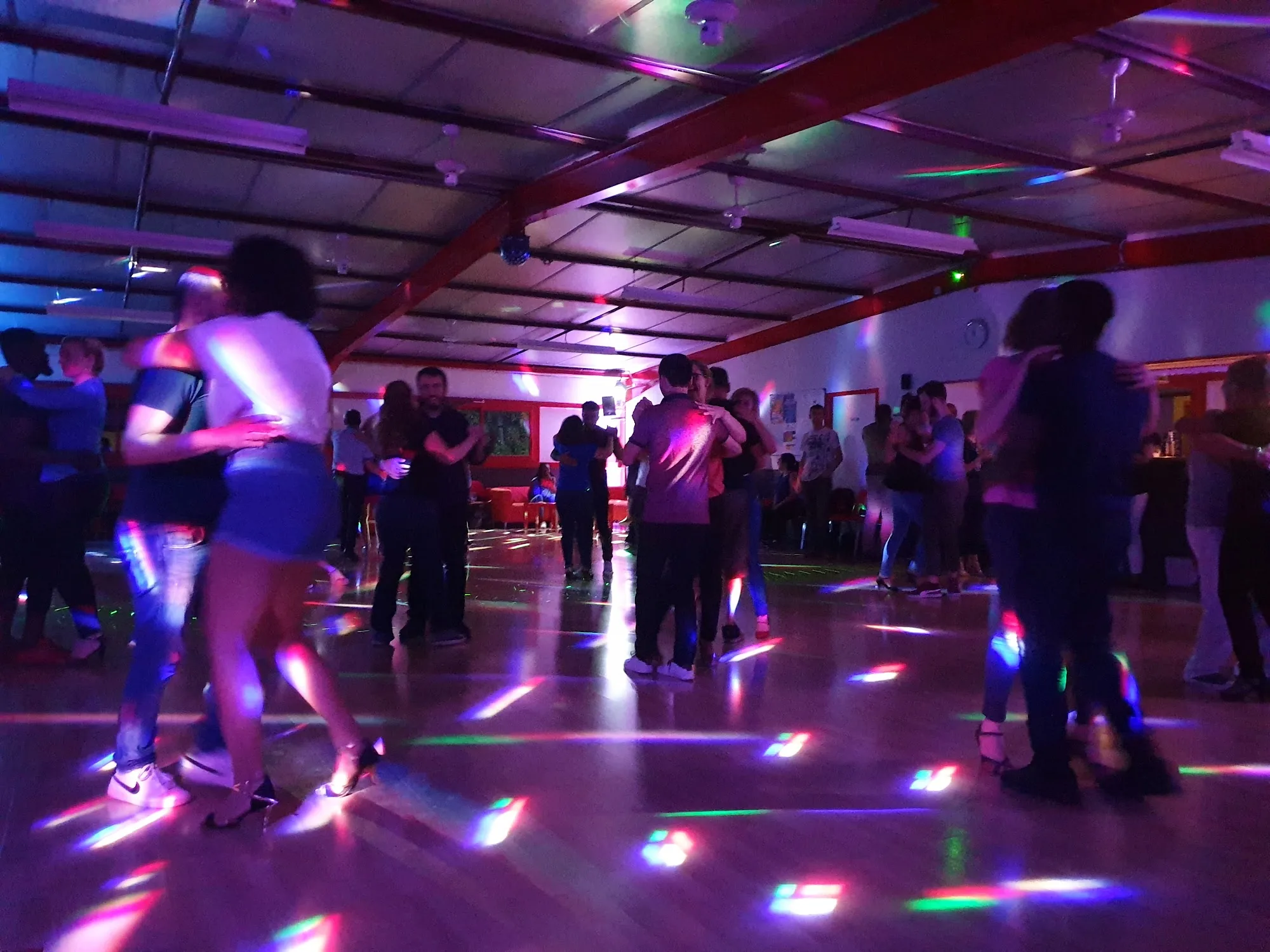Packed salsa social dance floor at Salle Le Temple Pessac with colourful party lights