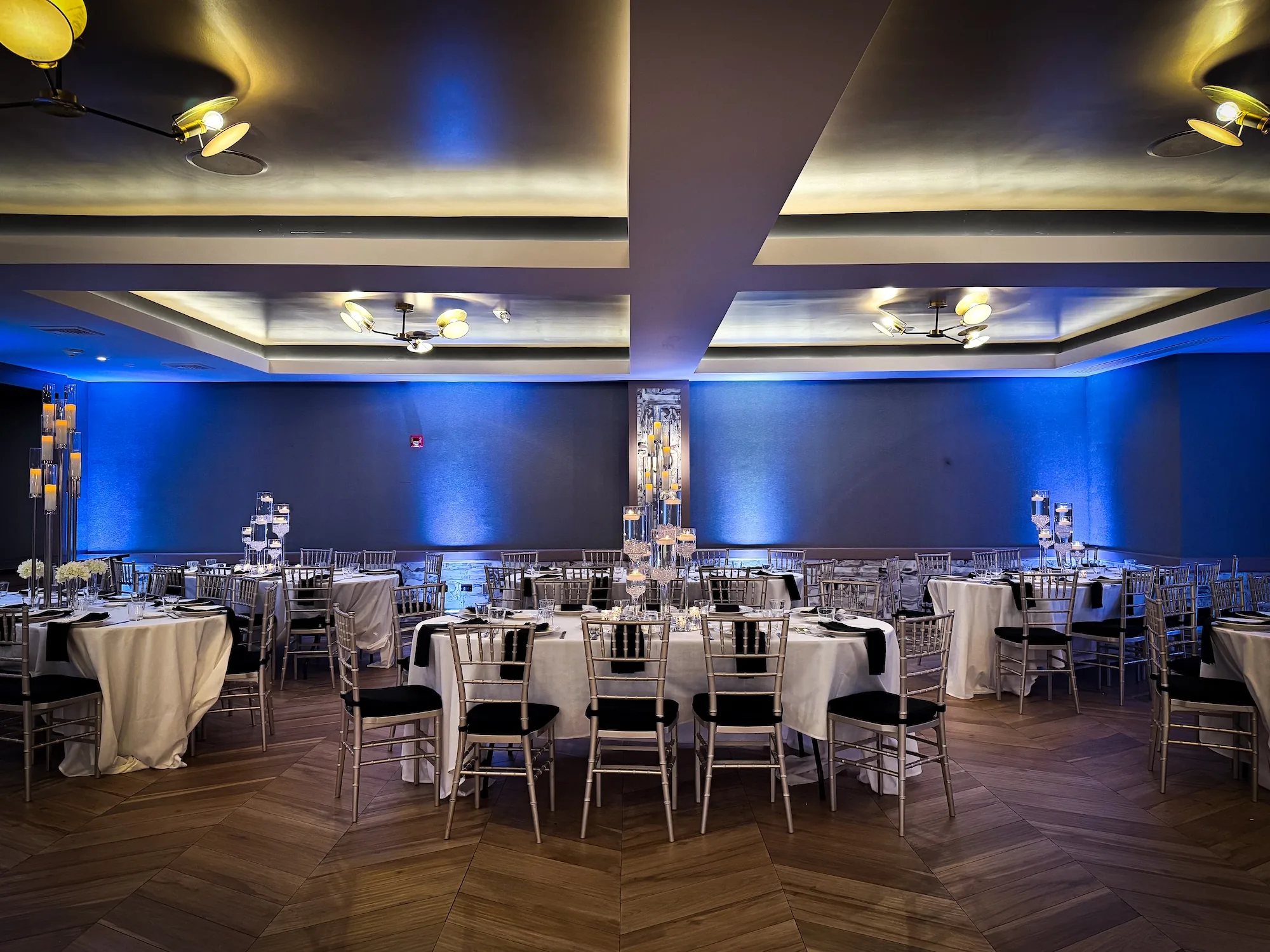 Event hall interior with chevron wooden floor and blue uplighting at K. Pacho New York