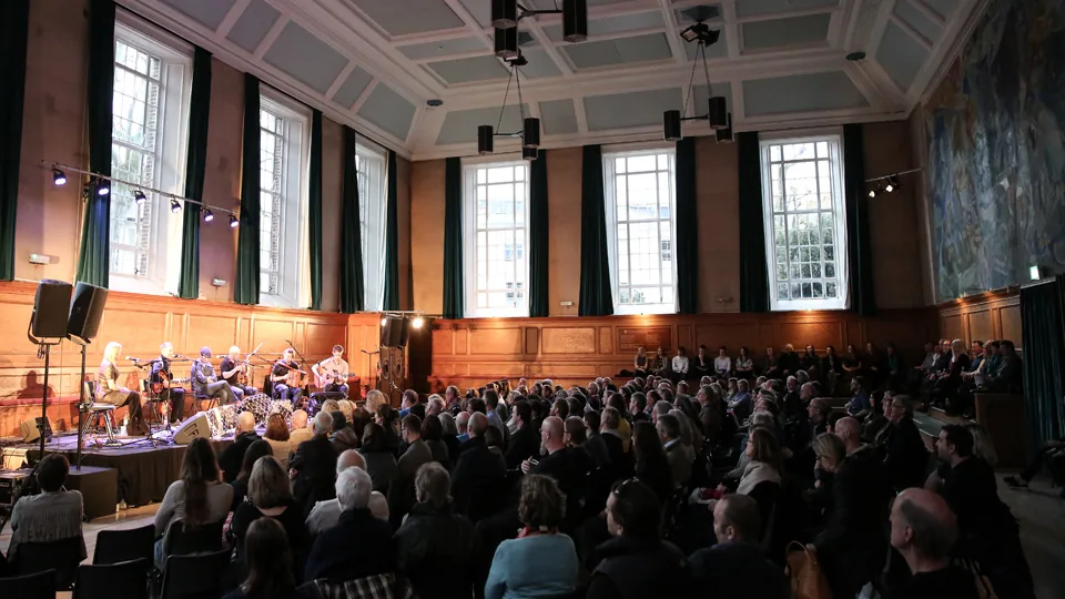 Packed Kennedy Hall audience at a live music event inside Cecil Sharp House, London