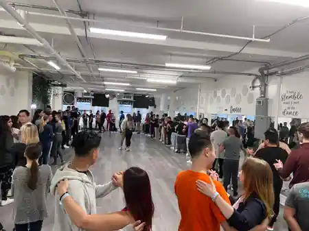 Bachata dance class at KTown Dance Studio in New York with couples practicing partner work on a packed dance floor