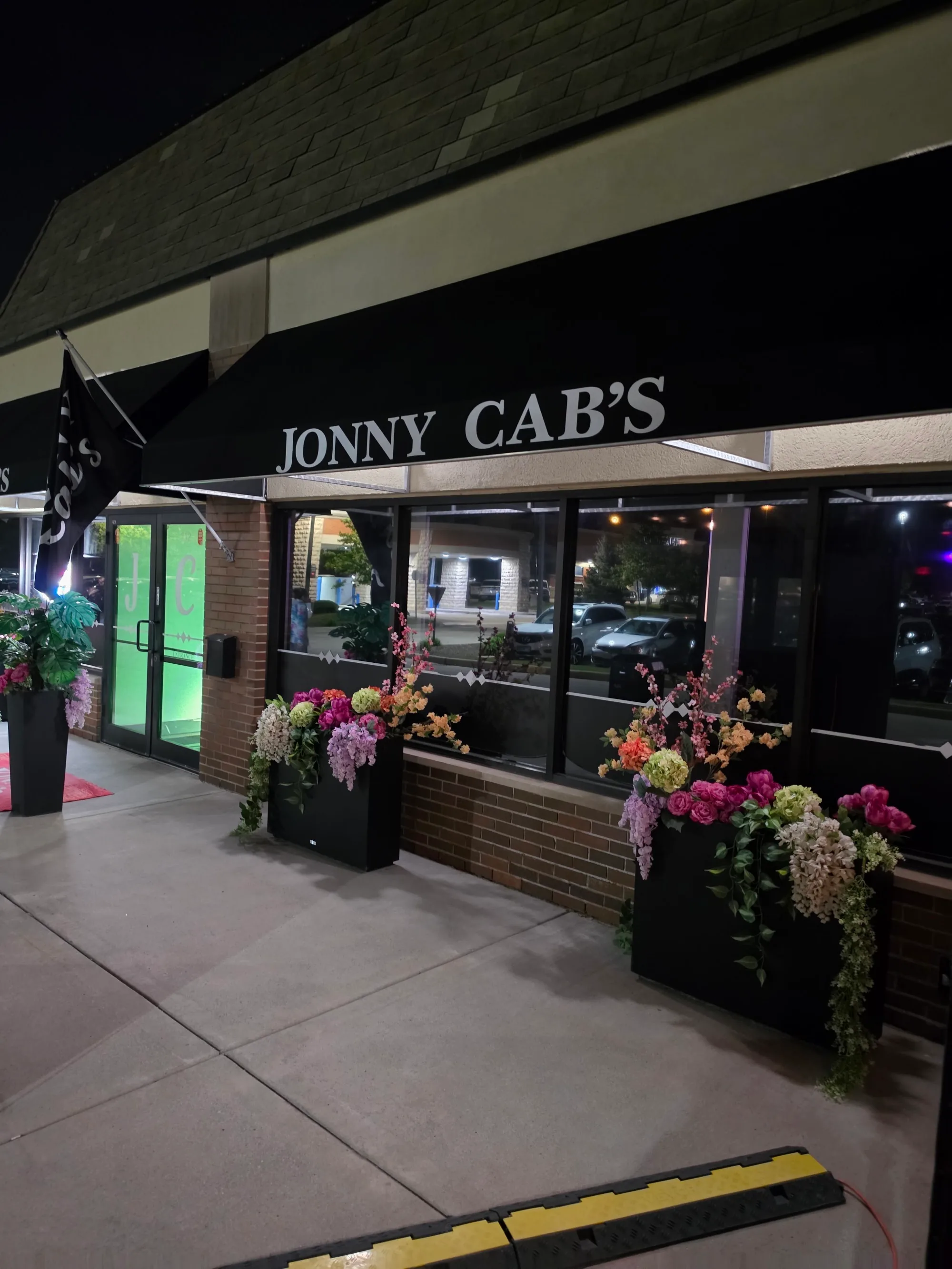 Jonny Cab's entrance and lit signage at night in Burr Ridge