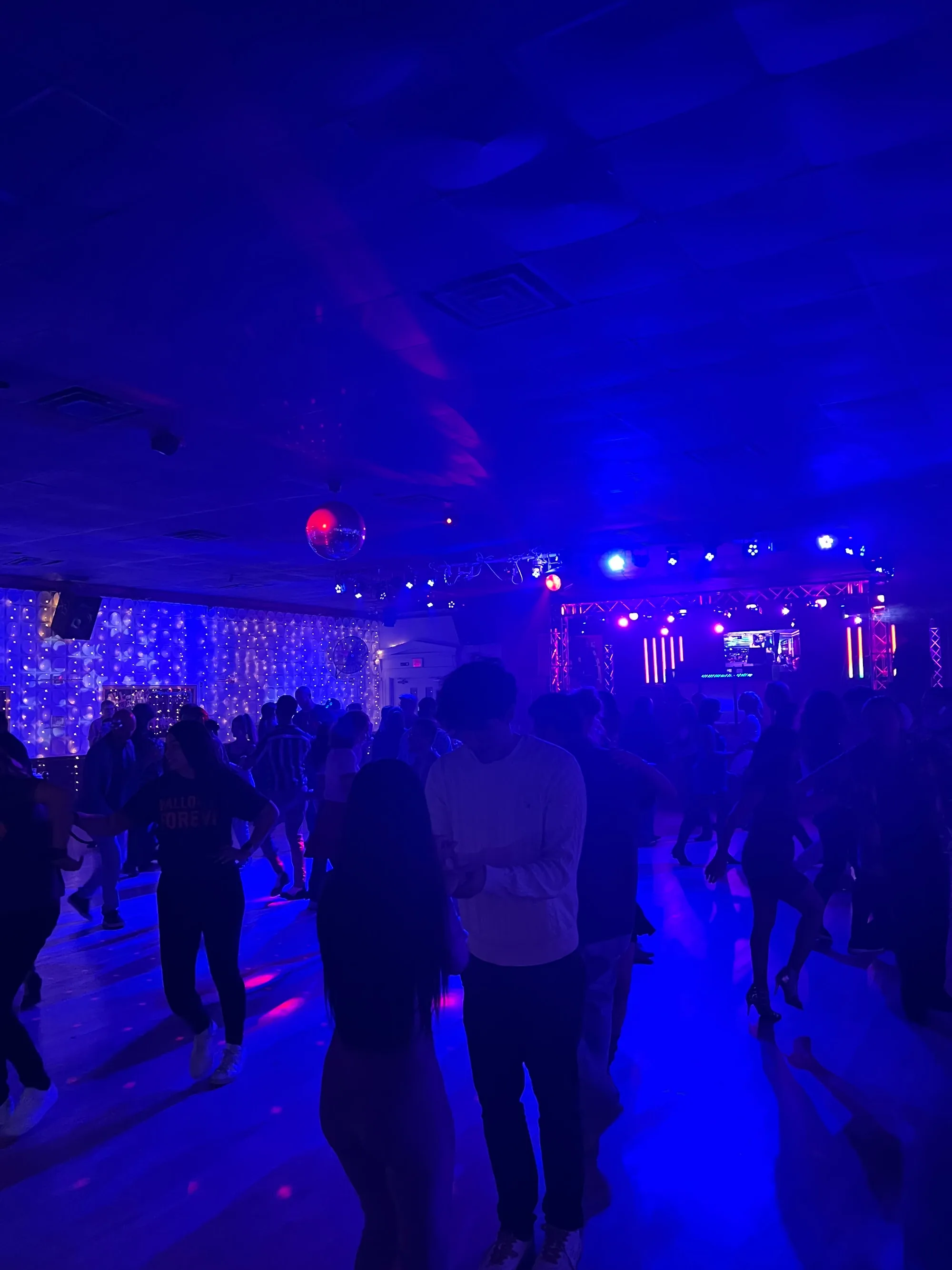 Crowd social dancing under blue club lights at Havana Club Cambridge