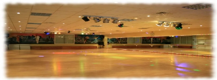 Large dance hall with colored stage lighting at École de Danse Mansouri Dijon France