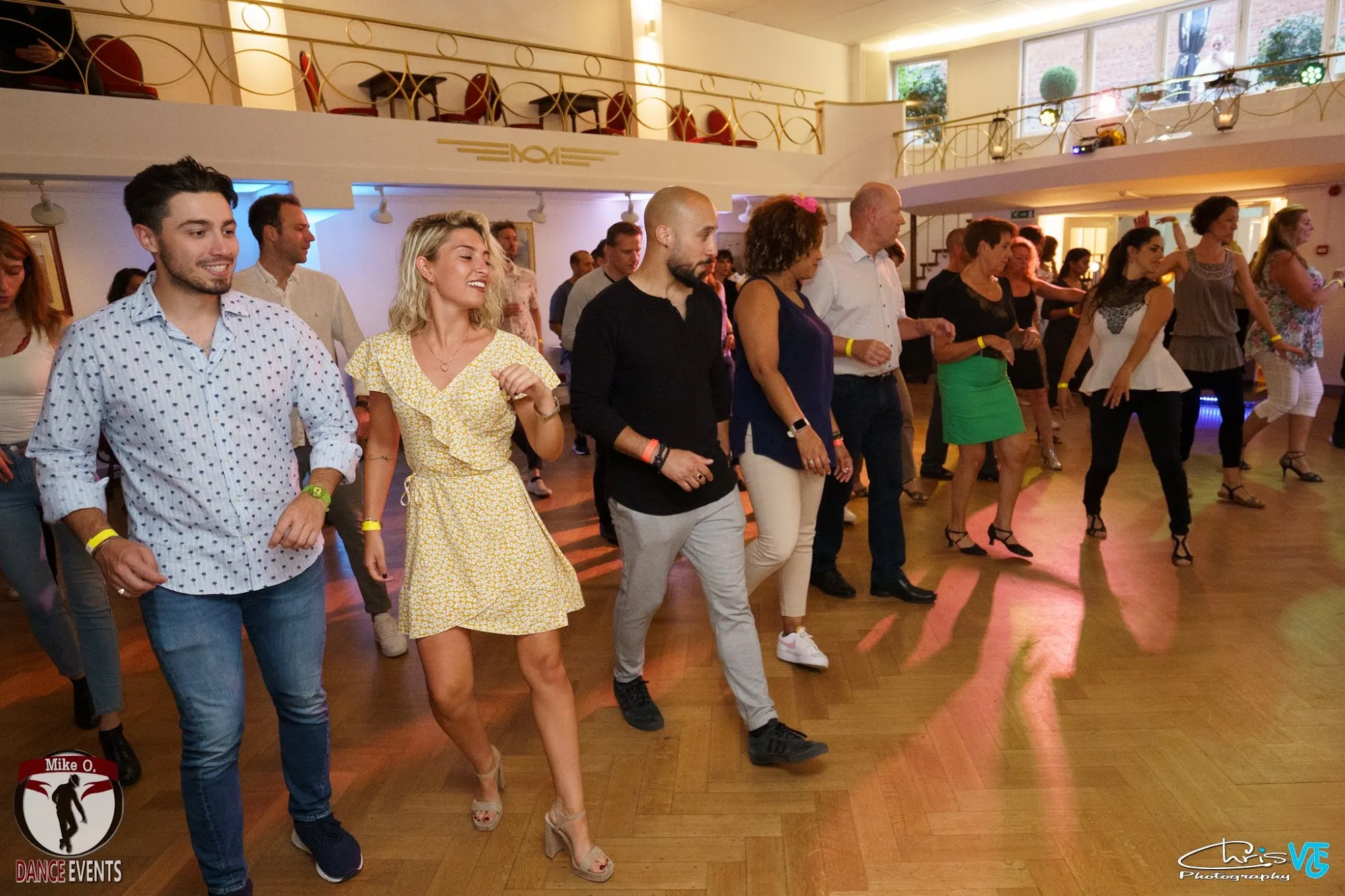 O'Dance Brussels — couples salsa dancing on the parquet floor with disco lighting