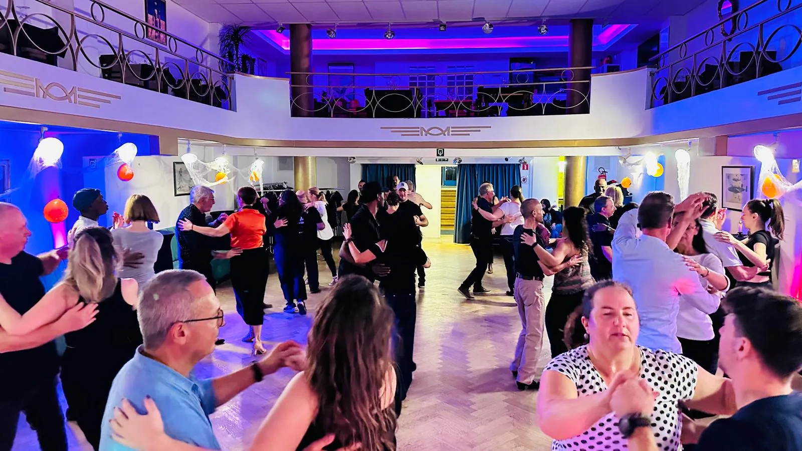 O'Dance Brussels event night — packed dance floor with couples in partner hold under colourful lighting