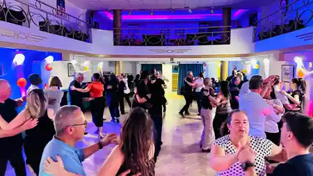 O'Dance Brussels event night — packed dance floor with couples in partner hold under colourful lighting — salsa, bachata, kizomba venue in Brussels