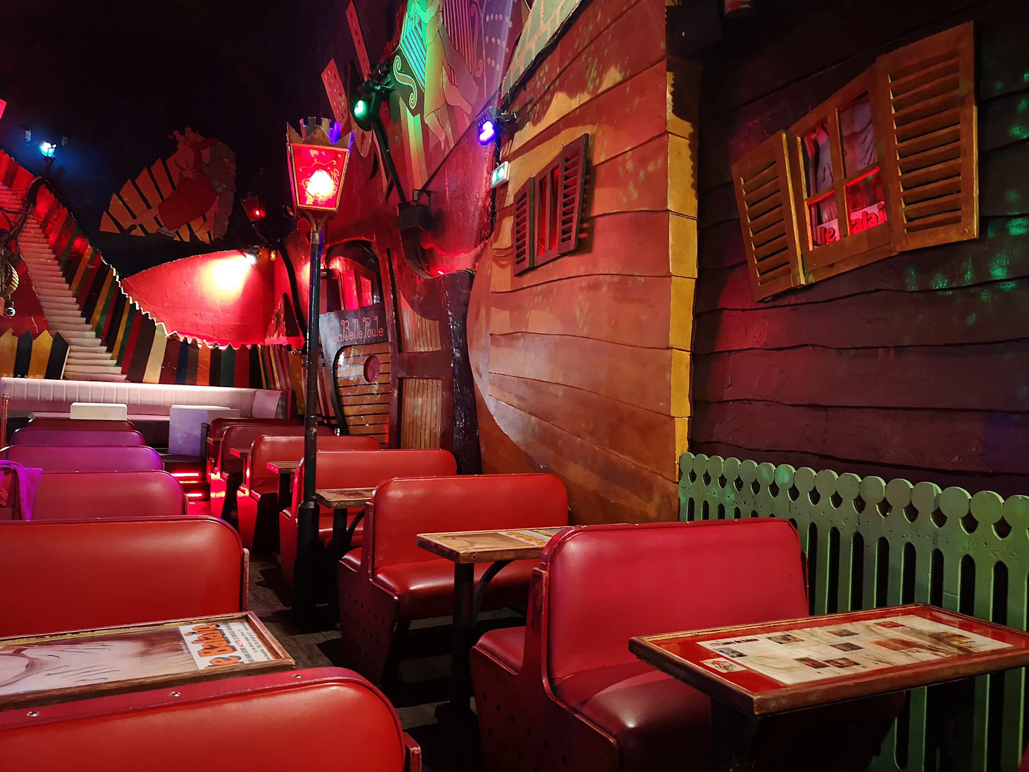 Quirky theatrical interior of Le Balajo with red booth seating and decorative themed decor
