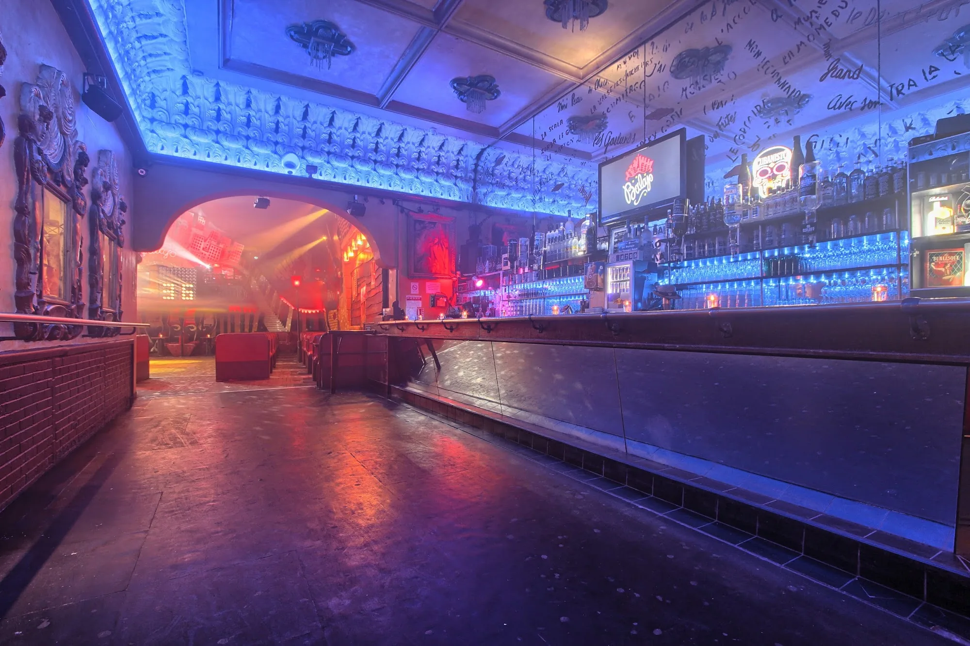Empty bar and dance floor at Le Balajo bathed in blue neon lighting