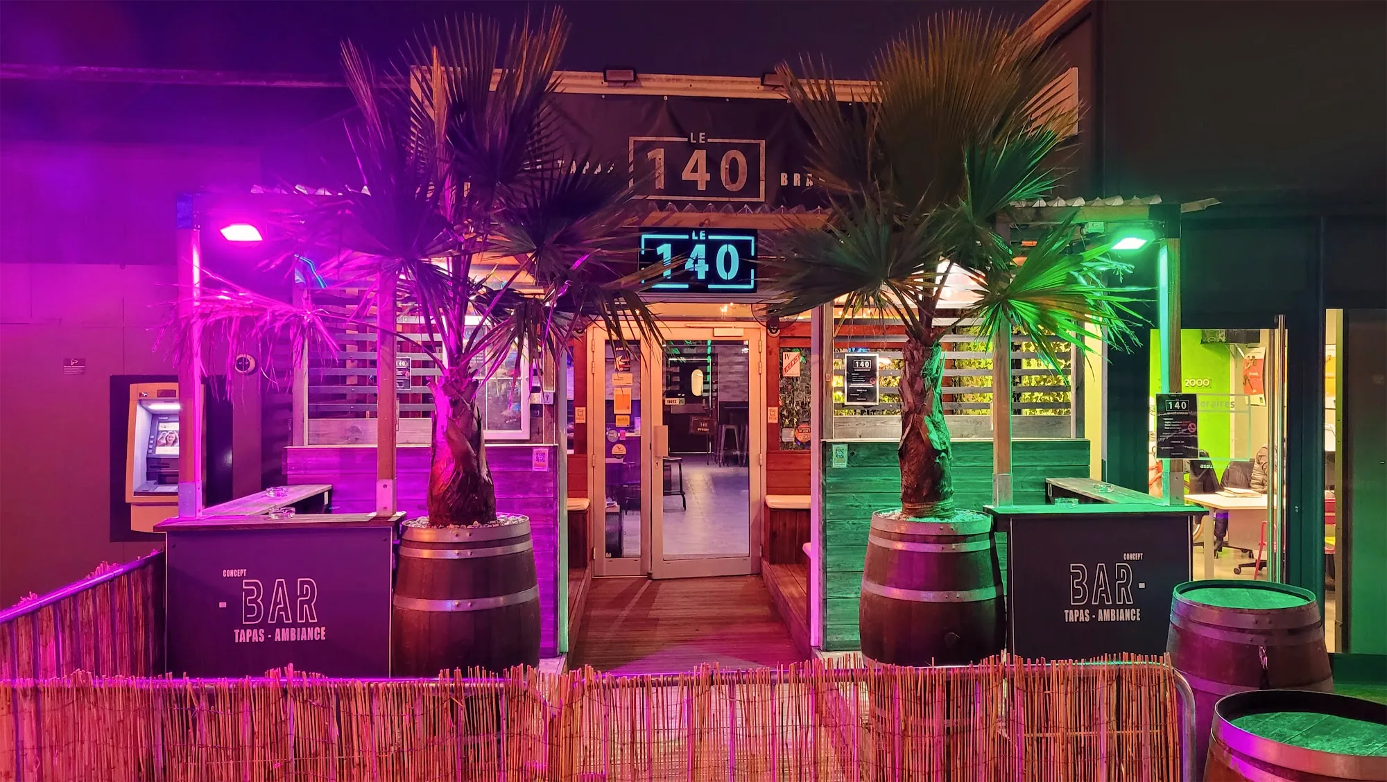 140 Bar neon entrance sign at night reading Bar Tapas Ambiance