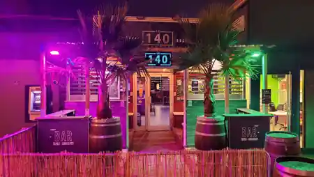 140 Bar neon entrance sign at night reading Bar Tapas Ambiance — salsa venue in Villenave-d'Ornon