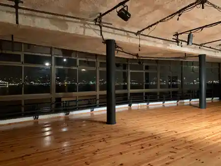 Wooden dance floor with stage lighting and Lisbon skyline view at Ponto de Encontro, Almada — bachata venue in Almada