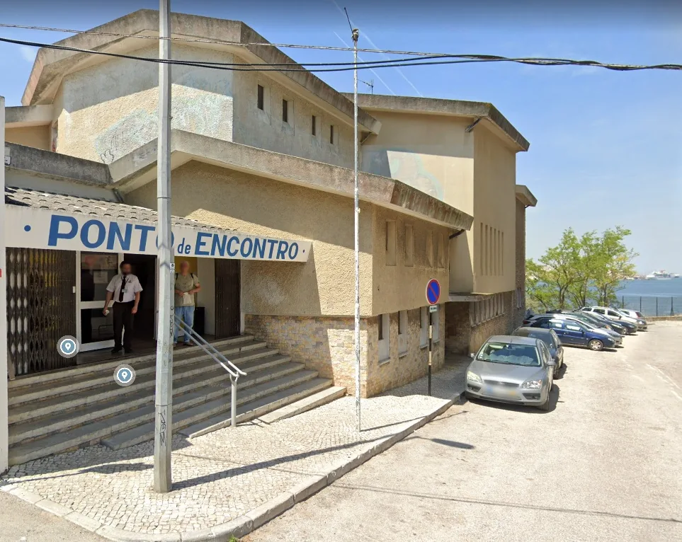 Full exterior of Ponto de Encontro Casa Municipal da Juventude with riverside backdrop in Almada