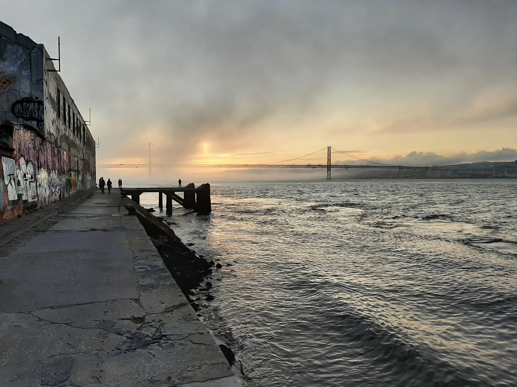 Riverside walkway leading to Ponto de Encontro at sunset in Almada, Portugal
