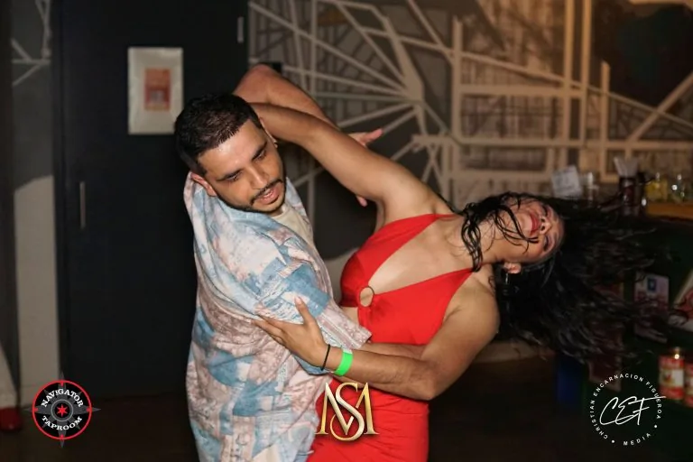 Couple performing an energetic bachata dip at a social dance night at 230 Fifth in New York City