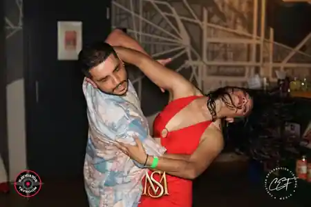 Couple performing an energetic bachata dip at a social dance night at 230 Fifth in New York City