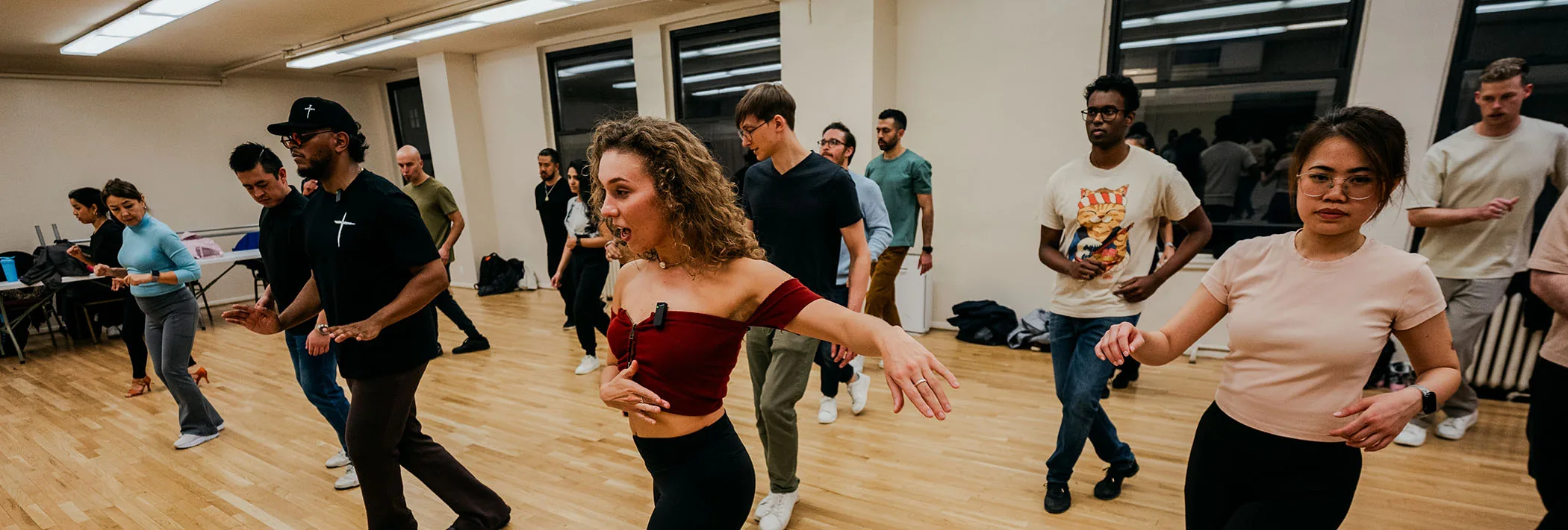 Dance class at 230 Fifth in New York City with dancers practicing salsa and bachata moves on a wooden studio floor