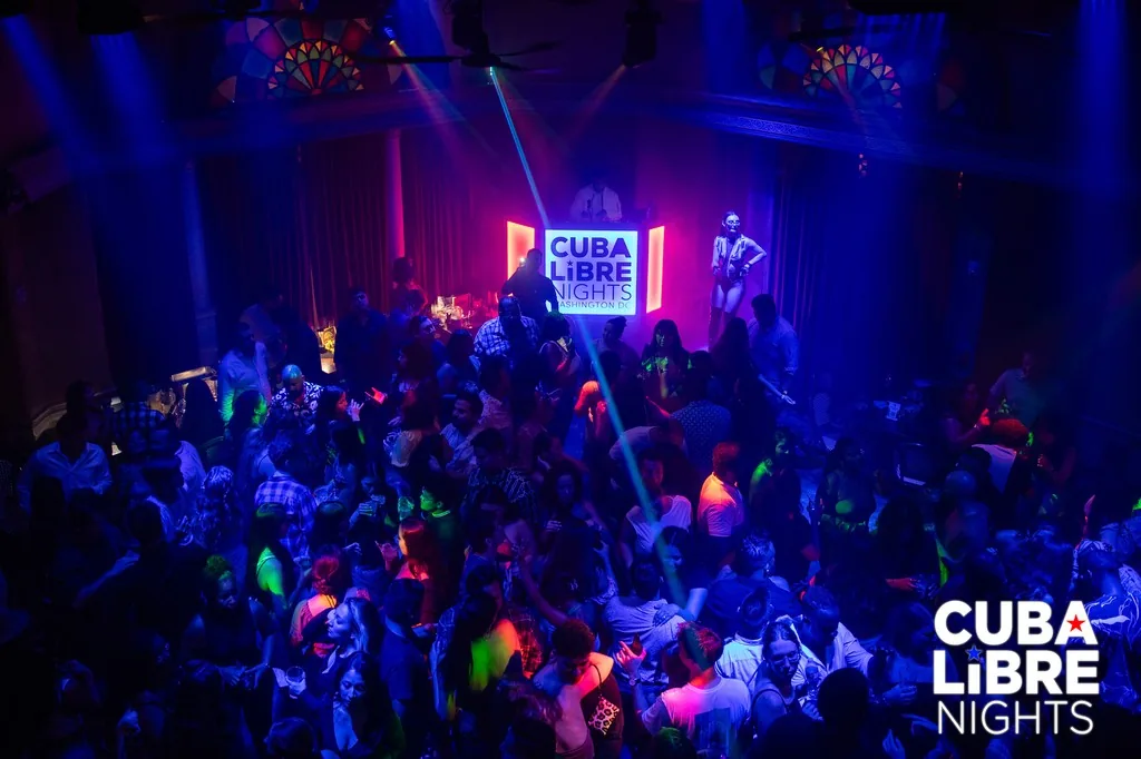 Packed dance floor at Cuba Libre Restaurant and Rum Bar in Washington D.C. with dancers under colorful neon lights during a Latin night — salsa, bachata venue in Washington, D.C.