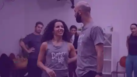 Dance instructors wearing Dance for Life shirts demonstrating partner work at Rio Rhythmics Latin Dance Academy in Brisbane — salsa, bachata, zouk, kizomba venue in Brisbane