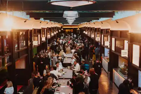 Boxhall City interior packed with guests on launch night, long communal tables with food vendors on both sides — bachata, salsa venue in London