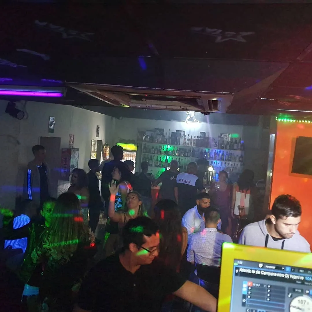 Crowded party night at Disco Star Corralejo with DJ booth and bar in background