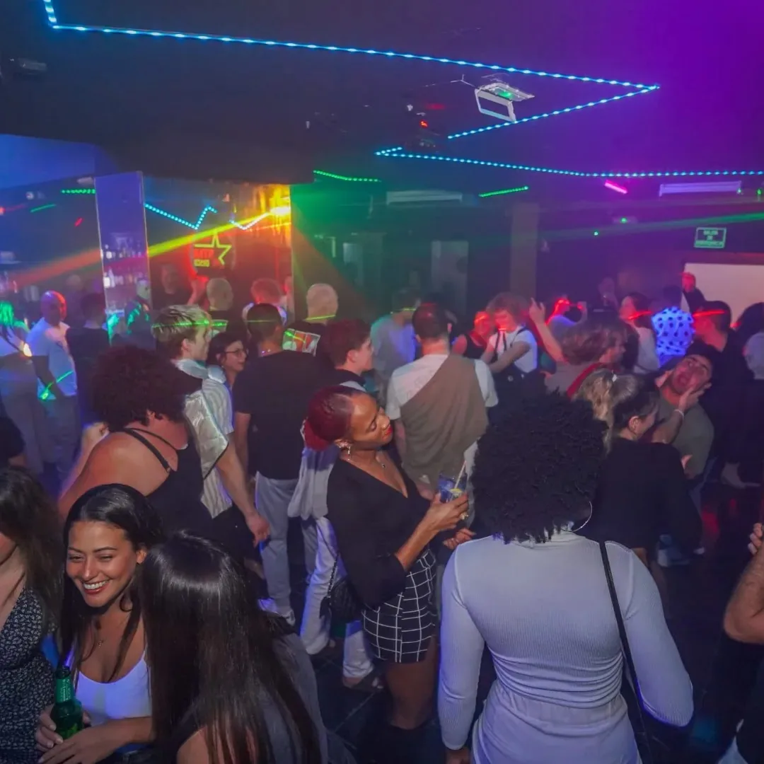 Packed Disco Star Corralejo dance floor with neon LED ceiling lights and party crowd
